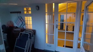 A room with a large window, a door, and a chair. - 3 bedroom holiday bungalow on the beach front, Point Clear Essex (Clacton)