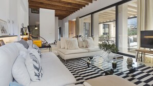 A modern living room with a sofa, coffee table, and large windows.