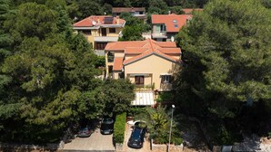Un barrio residencial con casas de tejas rojas y un edificio central con balcón.