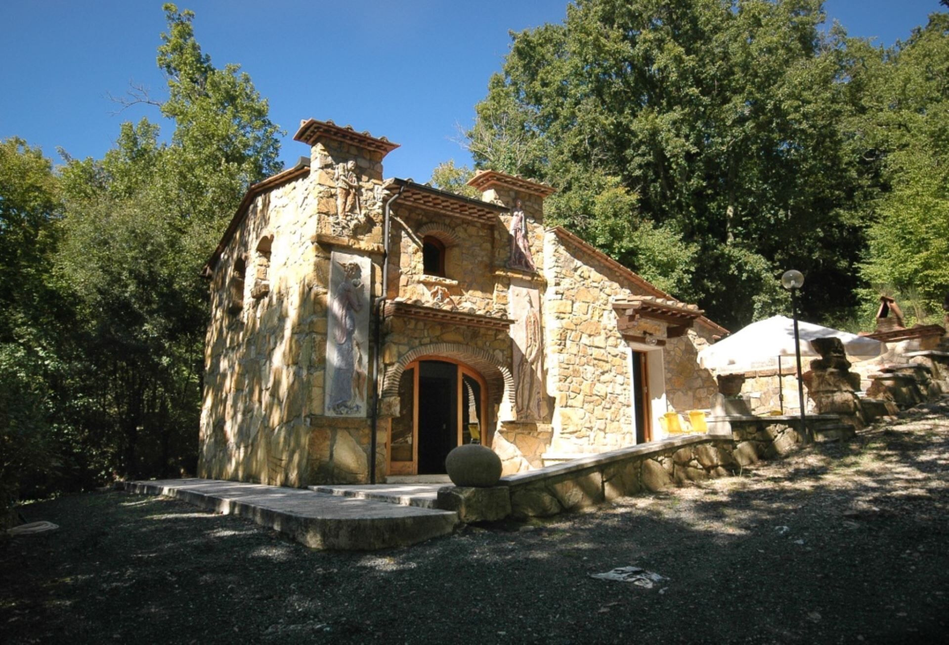 A rustic stone building with a wooden door and a small porch.
