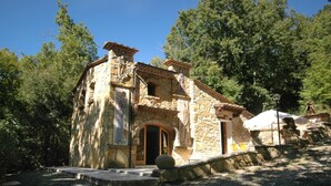 Ein rustikales Steinhaus mit einer Holztür und einer kleinen Veranda.