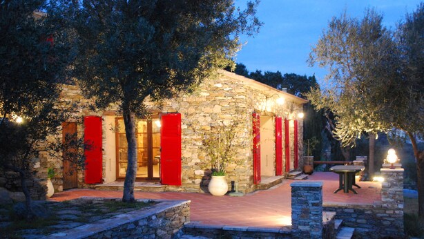 A stone building with red shutters, a paved patio, and outdoor seating. - Bastia charming building - Corsica 3 minutes from the beaches (Bastia)