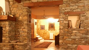A stone-walled hallway leading to a dining area with a red tablecloth. - Bastia charming building - Corsica 3 minutes from the beaches (Bastia)