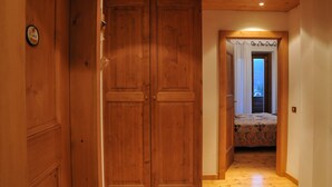 A hallway with wooden doors and a bed with a floral bedspread.