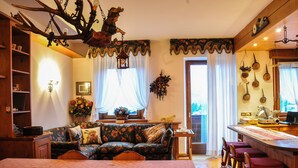 A cozy room with a bed, a sofa, a dining area, and a kitchen.