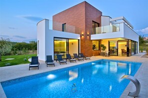 A modern two-story house with a swimming pool, lounge chairs, and a well-maintained garden. - Vibrant modern 5-BR Villa for 10+2, with pool and a sea view (Višnjan)