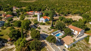 Une vue aérienne d’un village avec des maisons, une église et une piscine.