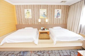 Habitación doble con dos camas, una mesita y una obra de arte en la pared.