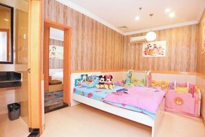 A bedroom with a wooden wall, a bed with a colorful bedspread, a small bedside table, and a wall-mounted air conditioner.