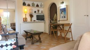 Una sala de estar con sofá, mesa de centro, televisor y chimenea.