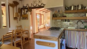 Una cocina con una isla central, sillas de madera, una mesa de comedor y vistas al área de comedor.