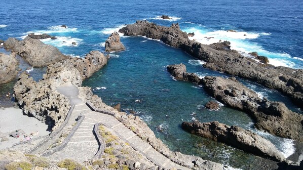 A coastal landscape with rocky formations and clear blue water. - El Lagar de Piedra, in San Juan de la Rambla - Tenerife (San Juan de la Rambla)