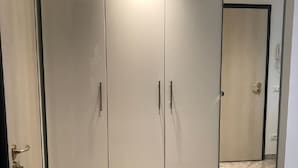 Una habitación con un armario grande, un espejo y suelo de baldosas.