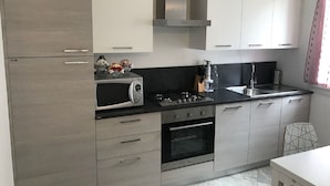 Una cocina moderna con microondas, estufa, horno y armarios.