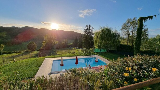 A rectangular swimming pool with a clear view of the surrounding landscape, including a grassy area and trees. - Detached house, private swimming pool, private fenced garden, panoramic view (Montopoli in val d'Arno)