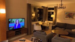 Un salon moderne comprenant un téléviseur, un coin repas et un espace détente.