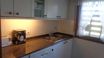 Een koelkast, een magnetron, een kookplaat, een vaatwasser