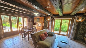 A cozy room with a sofa, a dining table, and a kitchen area.