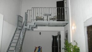 A white building with a staircase leading to a balcony. - Spacious apartment in restored manor house on Tavira riverfront (WiFi) (Tavira)