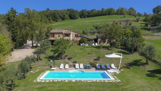 A large house with a swimming pool surrounded by lounge chairs and a stone wall. - Charming Villa in Marche, private pool and fantastic landscape (Gauldo, Macerata)
