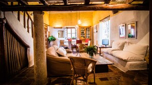 A cozy living room with a sofa, chairs, a coffee table, and a television. - Casa rural La Alameda for 6 people (Madridejos)