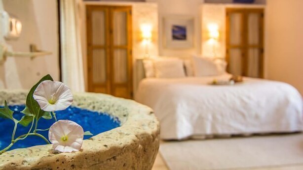 A hotel room with a bed, a nightstand, and a wall-mounted lamp. - Casa rural La Alameda for 6 people (Madridejos)