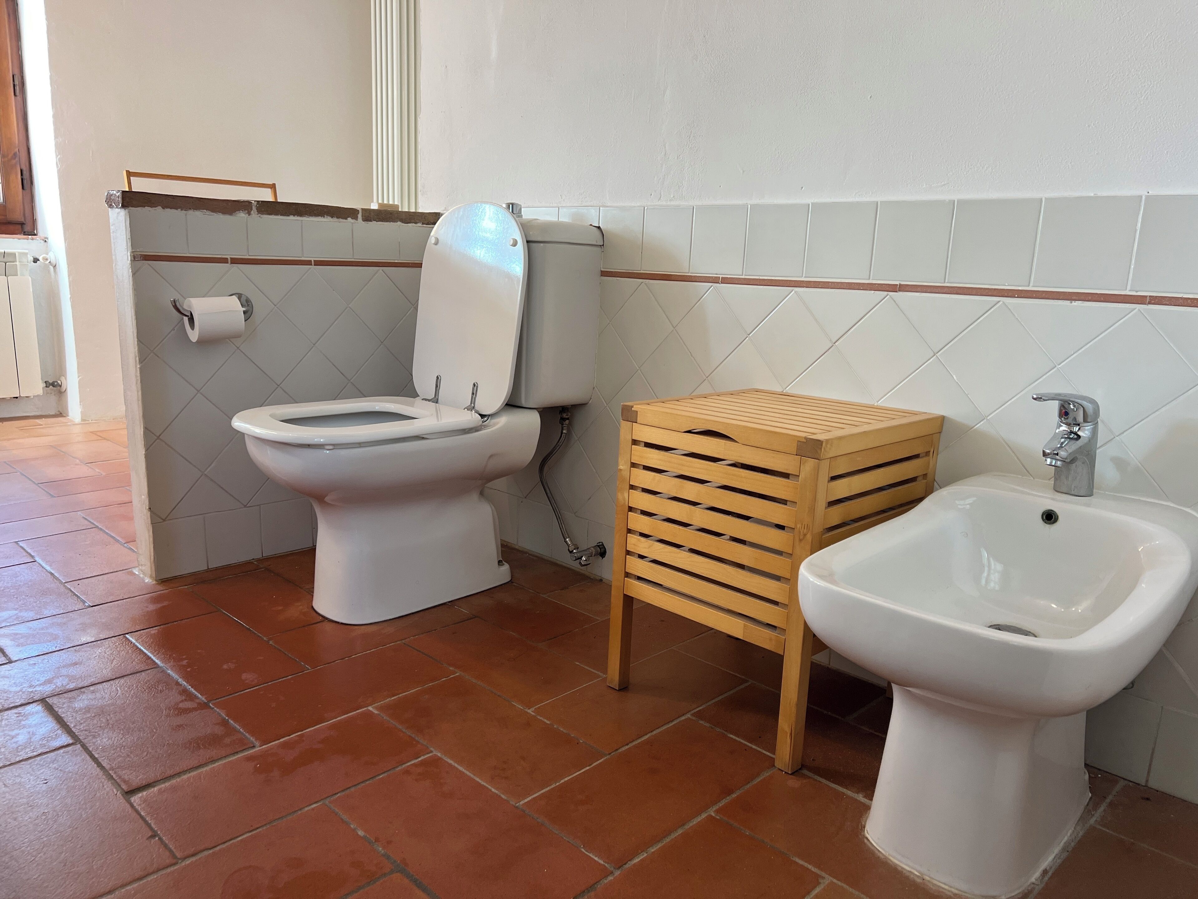 A bathroom with a toilet, bidet, and sink.