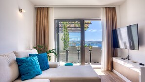 En moderne stue med sofa, TV og en balkon med udsigt.