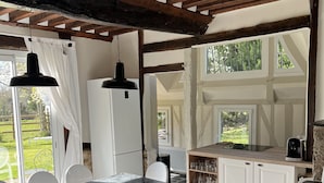 A rustic kitchen with a stone floor, white cabinets, and a wooden ceiling. - Full of charm, authentic and renovated cottage Honfleur (Normandy) (Honfleur)
