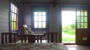 A room with a bed, a chair, and a door leading outside. - Holiday getaway, log burner, romantic retreat (Blaenffos, Boncath)