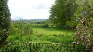 A rural landscape with a wooden fence, lush greenery, and a distant view of rolling hills. - Holiday getaway, log burner, romantic retreat (Blaenffos, Boncath)