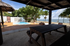 Relax on the deck, surrounded by lush greenery and overlooking the ocean.