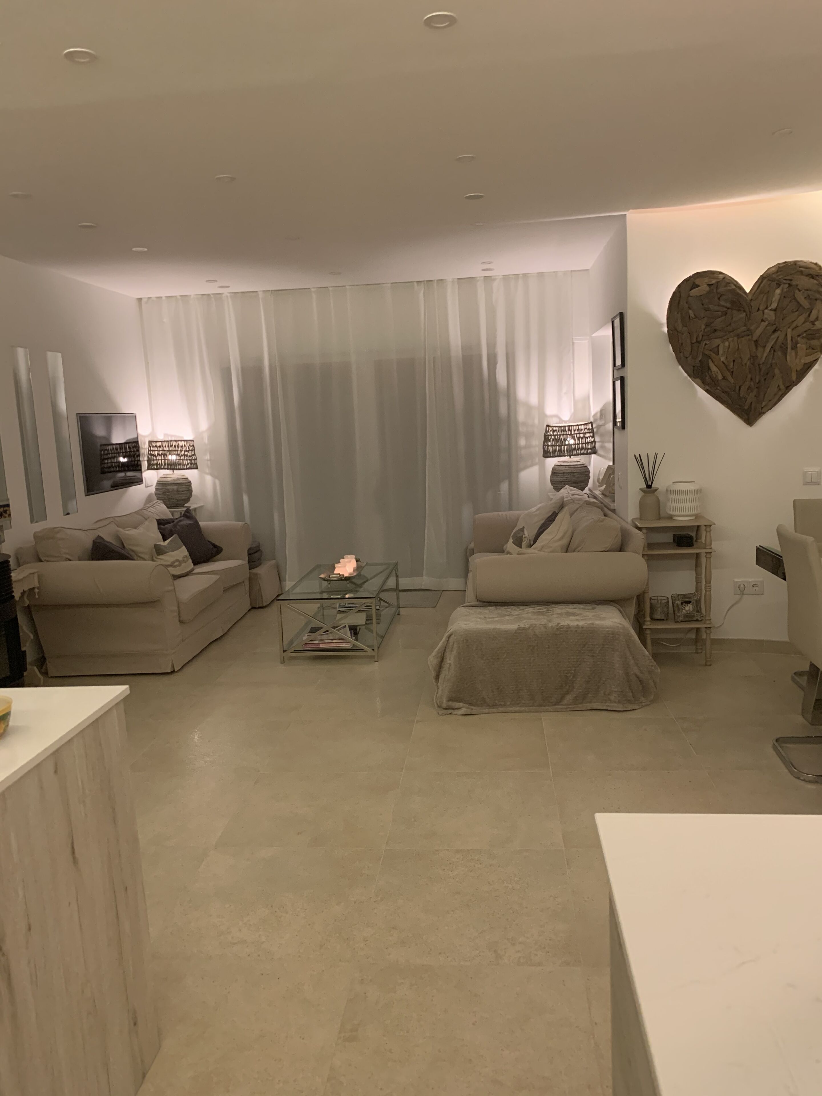 Una sala de estar moderna con dos sofás, una mesa de centro y un televisor.