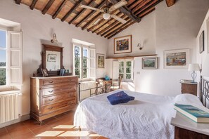 A bedroom with a bed, dresser, and a ceiling fan.