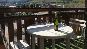 Ein Balkon mit Tisch, einer Champagnerflasche und zwei Gläsern.