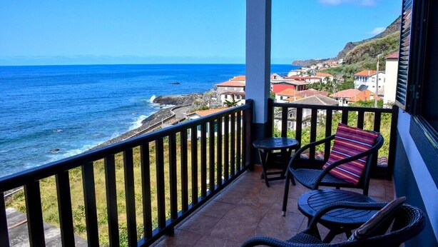 Varanda com vista para o oceano e uma cidade costeira.