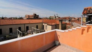 A rooftop terrace with a view of surrounding buildings, including a church with a dome. - Apartment A. Cà Canziani - On the roof in Venice (Venezia)