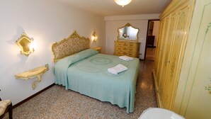 A bedroom with a bed, a dresser, a mirror, and a wardrobe. - Apartment A. Cà Canziani - On the roof in Venice (Venezia)