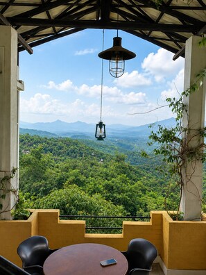 Ein Sitzbereich im Freien mit Tisch und Stühlen mit Blick auf eine Berglandschaft.