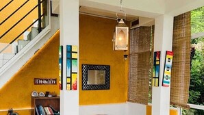 A room with a sofa, a chair, a bookshelf, and a staircase. - Your Private Mountain Escape in Kandy - Eagles' Nest (Moragolla)