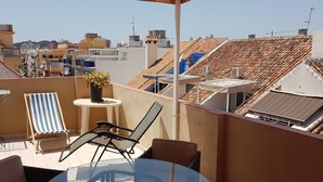 A rooftop terrace with a table, chairs, and a potted plant. - Large sunny terrace, 6à m from the beach; large and comfortable (Fuengirola)