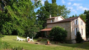 A stone house with a tiled roof, surrounded by a well-maintained lawn and trees. - Mansion - BERGERAC (Bergerac)