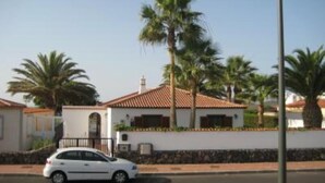 A white car parked in front of a building with a tiled roof and palm trees. - House / Villa with private pool (San Miguel de Abona)