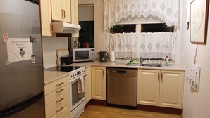 A kitchen with a refrigerator, microwave, stove, and dishwasher.
