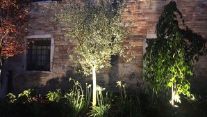 Un bâtiment en briques avec une fenêtre et un arbre devant.