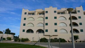 A multi-story building with a symmetrical facade, featuring arched windows and a central entrance. -  Apartment sea view in Salgados Village (Guia)
