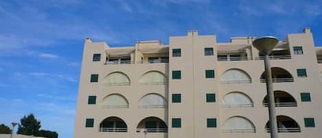 Un edificio de varios pisos con fachada simétrica, que presenta ventanas en arco y una entrada central.