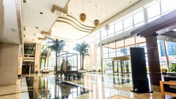 A spacious lobby with a reflective floor, large windows, and a statue in the center. - Jinling Danyang Hotel (Danyang)