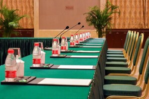 A conference room with a long table, chairs, microphones, water bottles, and nameplates. - Jinling Danyang Hotel (Danyang)