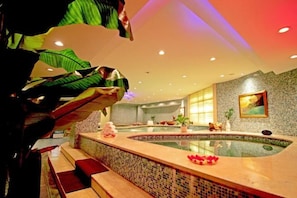 A spa area with a hot tub, seating, and a decorative plant. - Jinling Danyang Hotel (Danyang)